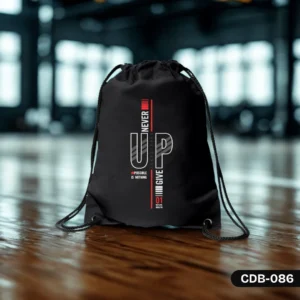 "Level Up Drawstring Bag (CDB-086) in black, featuring a modern white and red typographical design with 'NEVER GIVE UP,' 'IMPOSSIBLE IS NOTHING,' and 'STAY STRONG' text, photographed on a polished wooden floor with a blurred gym or studio background."