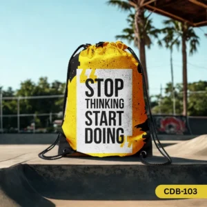 "The Action Trigger yellow and black drawstring bag with 'Stop Thinking Start Doing' quote, displayed at a skate park."