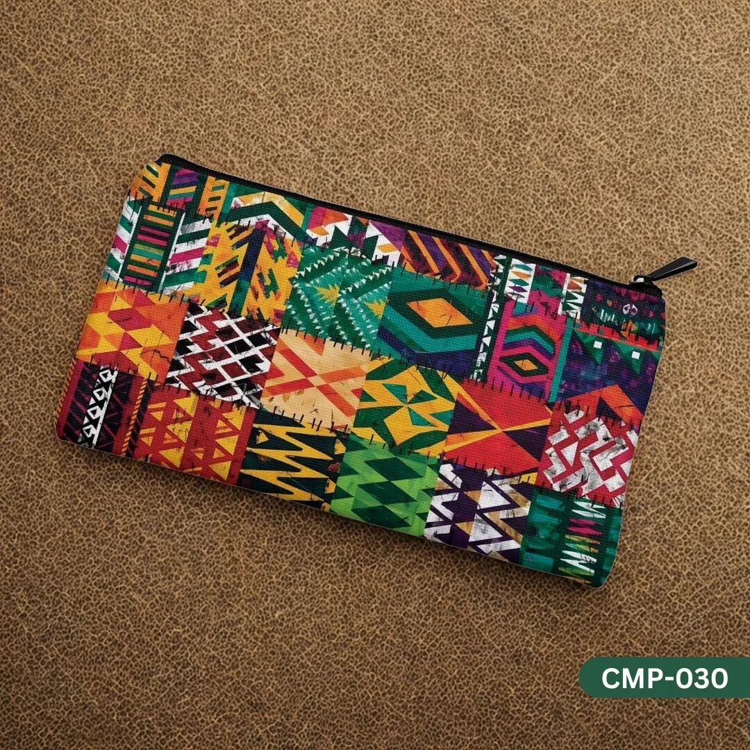 The Wanderlust Makeup Pouch with a colorful, tribal patchwork pattern, displayed on a brown textured leather surface.
