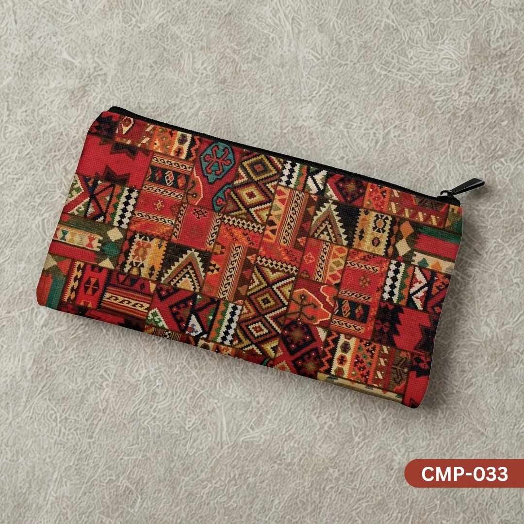 The Nomad's Fire Makeup Pouch with a rich red and orange Kilim rug patchwork pattern, shown on a textured beige background.