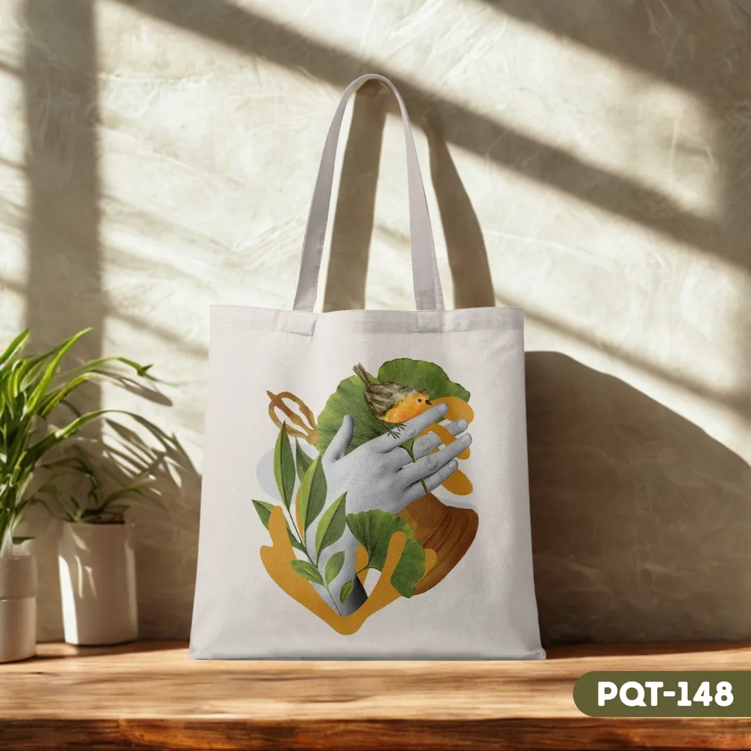 Whispers of the Wild Tote Bag (PQT-148) with an artistic collage design of hands cradling a bird among leaves, on a wooden surface with dappled sunlight.